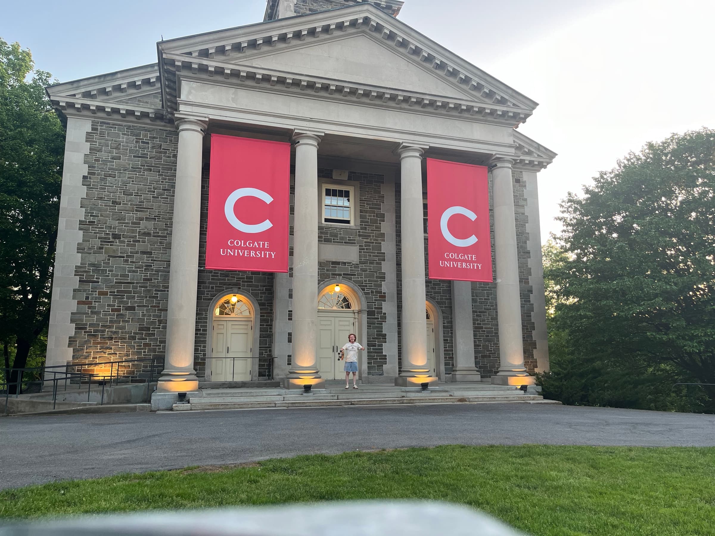 Ethan standing on the steps of a Colgate University building at dusk